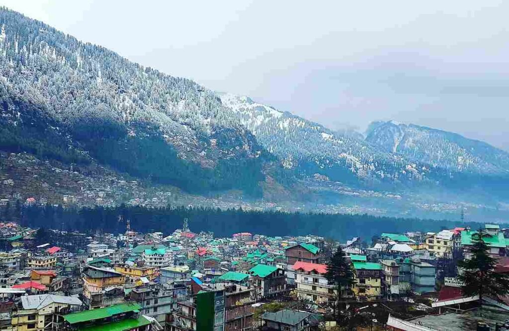 Snow-covered mountains and pine trees in Manali during winter